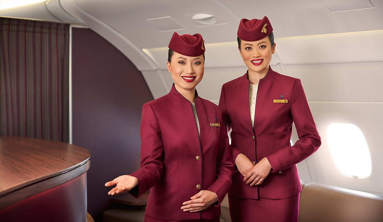 как устроиться на работу своей мечты и бесплатно путешествовать по миру, красивая бортпроводницы Qatar Airways в кабине самолета улыбаются, форма стюардессы