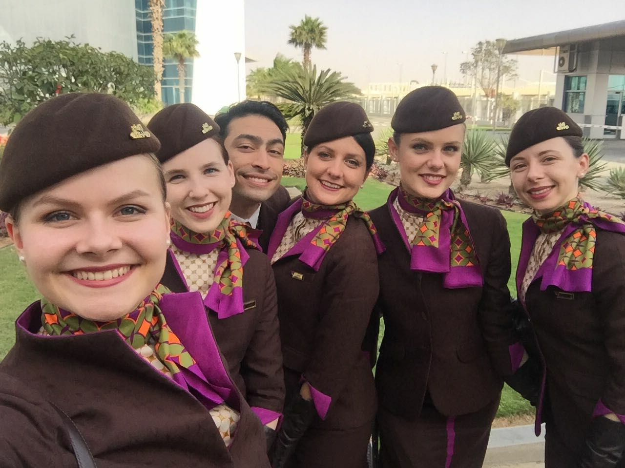 красивые бортпроводницы Qatar Airways в фирменной одежде улыбаются и делают селфи