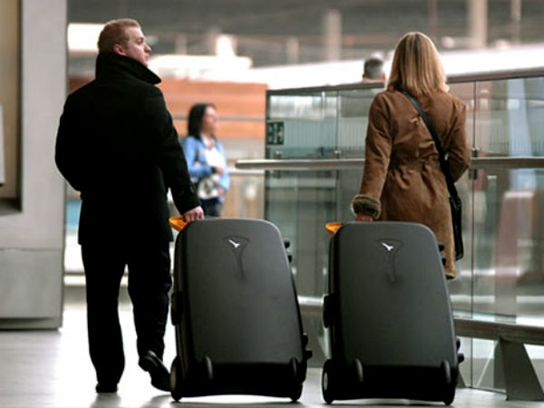семейная пара катит большие чемоданы в аэропорту