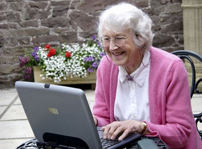 пенсионерка осваивает ноутбук - бабушка перед компьютером