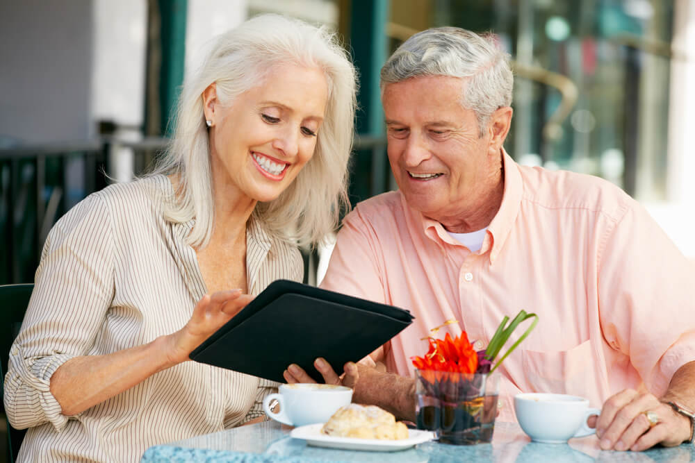 счастливые и довольные пенсионеры в США - влюбленная пара пьет кофе в летнем ресторане