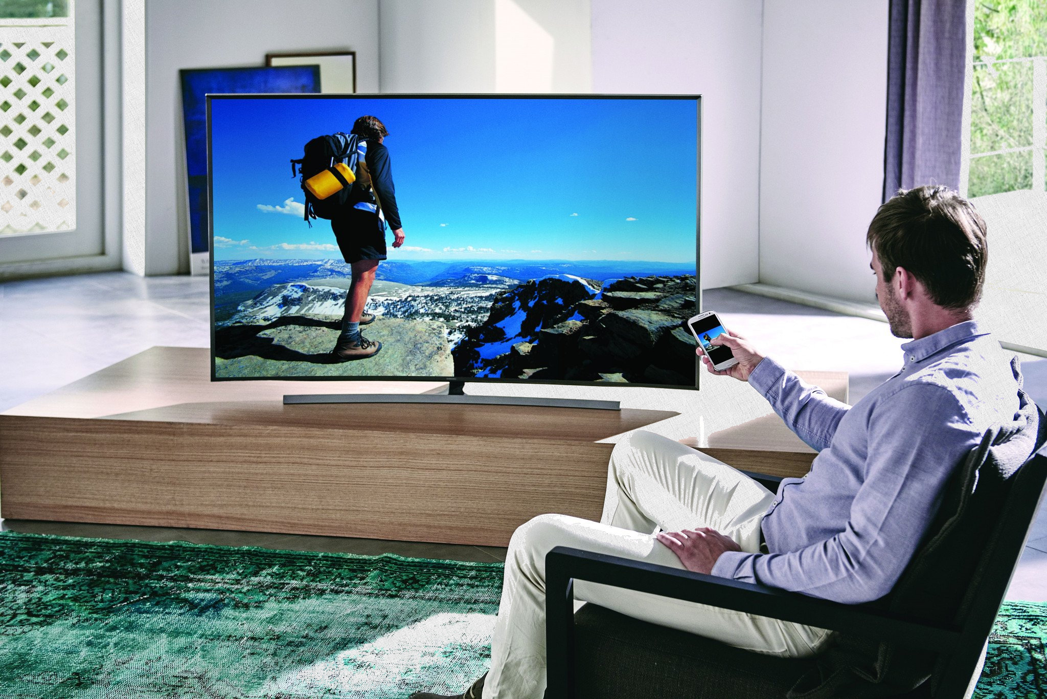 мужчина сидит перед большим плазменным телевизором - smart tv в доме как выглядит - стерео система фото