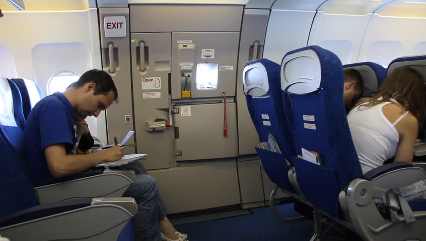 места в самолете перед аварийным выходом и почему у них не откидываются спинки - мужчина читает газету в самолете