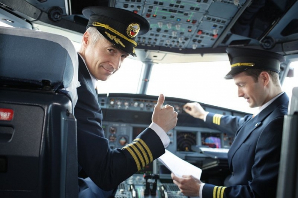 красивые пилоты в кабине самолета перед взлетом авиалайнера