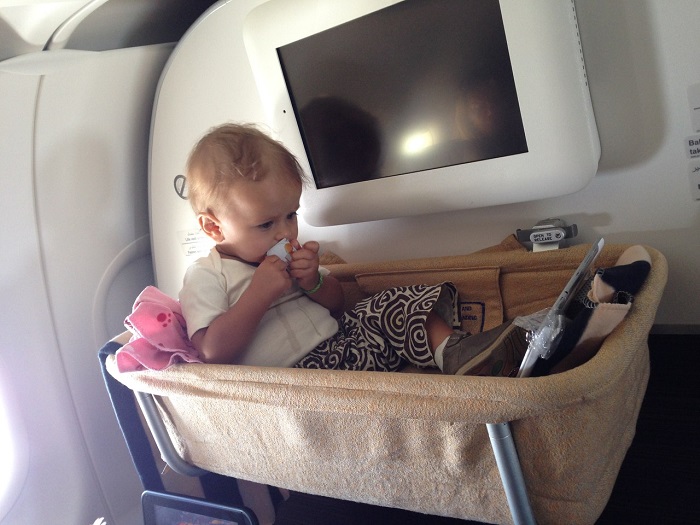 ребенок в люльке в самолете - места сразу за бизнес классом для мам с детьми на борту авиалайнера
